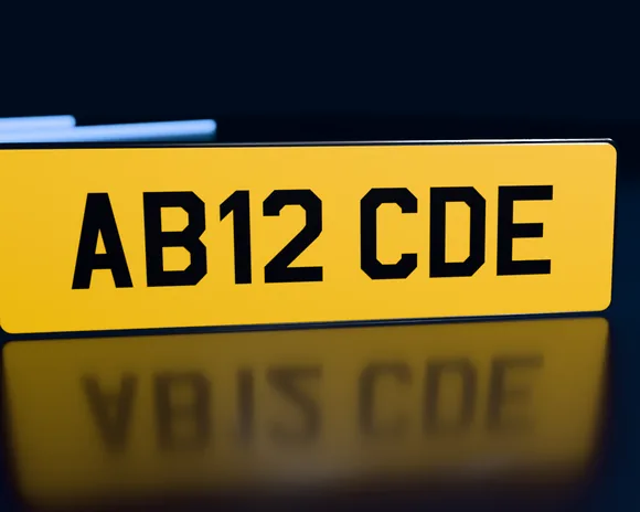A tall 533 × 152mm yellow rear number plate reading AB12 CDE