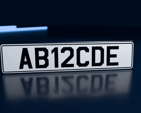 A white show plate reading AB12CDE with custom spacing and a black border