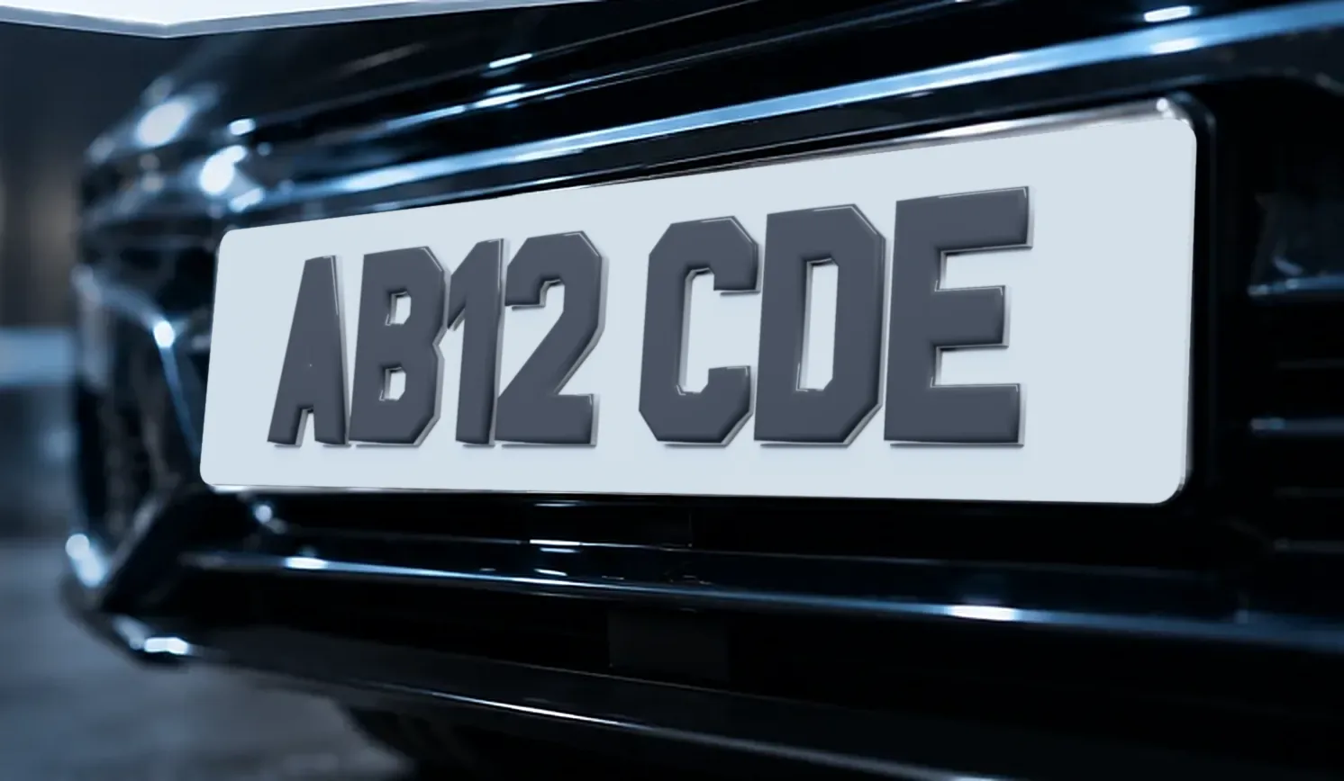 The front of a dark car fitted with a white Ghost number plate