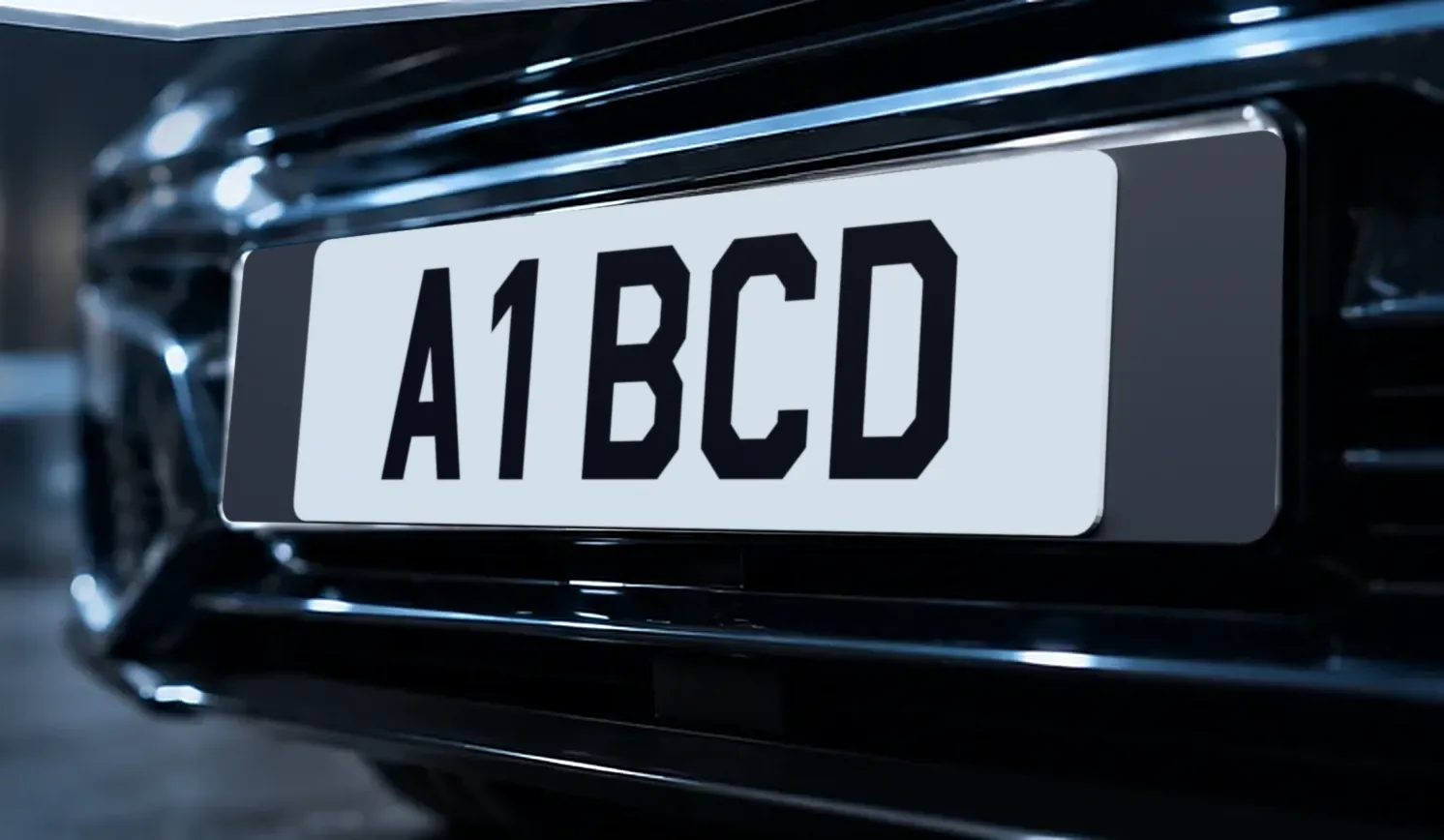 The front of a dark car fitted with a white short number plate